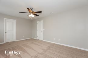 Troutman house for rent - a bedroom with a ceiling fan and a carpeted floor