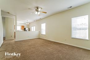Fuquay Varina house for rent - A spacious room with a ceiling fan and carpeted floor.
