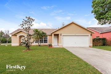 Kissimmee house for rent - a beige house with a white garage door and a lawn