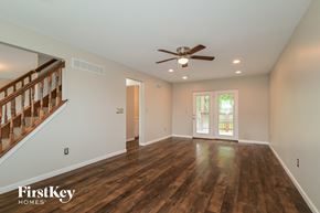 O'fallon house for rent - A spacious room with wooden floors and a ceiling fan.