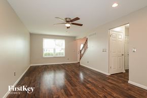 O'fallon house for rent - A spacious room with wooden floors and a ceiling fan.
