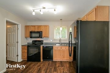 O'fallon house for rent - A kitchen with wooden cabinets and black appliances.