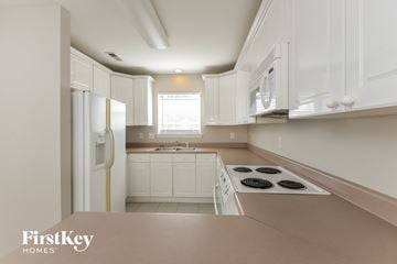 Birmingham house for rent - a white kitchen with white cabinets and a white refrigerator