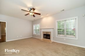 Acworth house for rent - A spacious living room with a fireplace and a ceiling fan.
