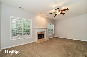 Acworth house for rent - A spacious room with a fireplace and a ceiling fan.