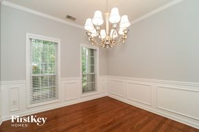 Acworth house for rent - A room with a chandelier and a window with blinds.