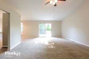 Avon house for rent - A spacious room with a carpeted floor and a ceiling fan.