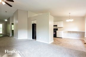 Avon house for rent - A spacious living room with a ceiling fan and a kitchen area in the background.