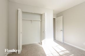 Avon house for rent - A white bedroom with a large open closet door.