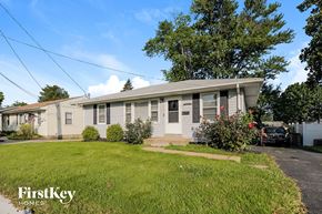 Florissant house for rent - A house with a grey roof and a red flower in front.