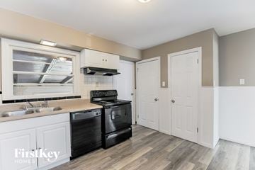 Florissant house for rent - A kitchen with a black stove top oven and white cabinets.