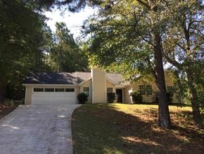 Covington house for rent - a yellow house with a driveway and trees