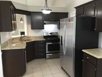 Covington house for rent - a kitchen with stainless steel appliances and black cabinets