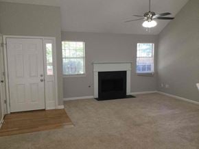 Covington house for rent - an empty living room with a fireplace and a ceiling fan