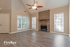 Covington house for rent - A spacious living room with a fireplace and a ceiling fan.