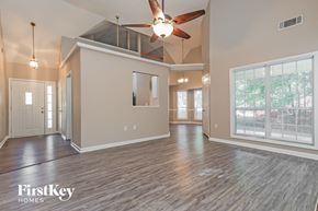 Covington house for rent - A spacious room with a ceiling fan and wooden flooring.