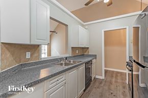 Covington house for rent - A kitchen with a granite countertop and white cabinets.