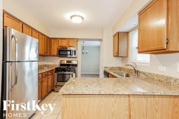 Lindenhurst house for rent - a kitchen with wooden cabinets and granite counter tops and stainless steel appliances