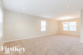 Lindenhurst house for rent - a spacious living room with carpeting and a chandelier