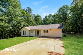Covington house for rent - a small white house with a driveway and grass and trees