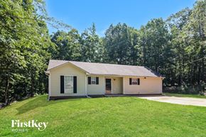 Covington house for rent - a small white house with a grassy yard and trees