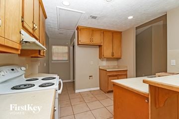 Covington house for rent - a kitchen with wooden cabinets and a stove top oven