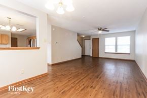Greenwood house for rent - A spacious room with wooden floors and a ceiling fan.