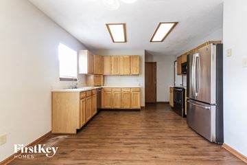 Greenwood house for rent - A kitchen with wooden cabinets and a stainless steel refrigerator.