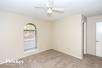 Garland house for rent - a living room with carpet and a ceiling fan
