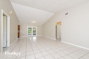 Sanford house for rent - a spacious living room with tiled flooring and white walls
