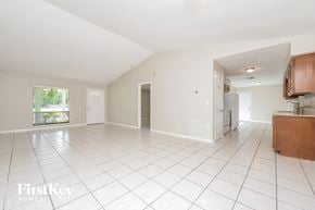 Sanford house for rent - an empty kitchen and living room with white tiled flooring