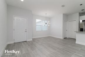 Poinciana house for rent - an empty living room with white walls and a white door
