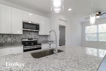 Poinciana house for rent - a white kitchen with a sink and a stove