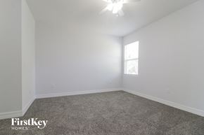 Poinciana house for rent - a bedroom with white walls and carpet and a window