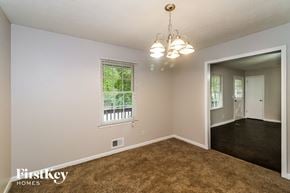 Woodstock house for rent - the living room and dining room of a house with carpeted flooring and a