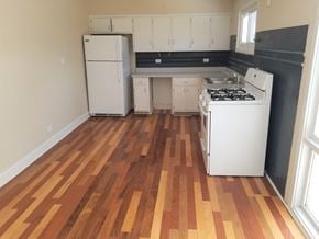 Mundelein house for rent - an empty kitchen with white appliances and wooden floors
