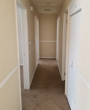 Mundelein house for rent - a hallway with a carpeted floor and beige walls and white doors