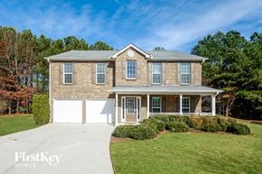 Acworth house for rent - a large brick house with a white garage and a driveway