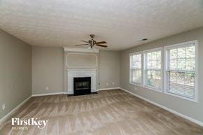 Acworth house for rent - a living room with a fireplace and a ceiling fan