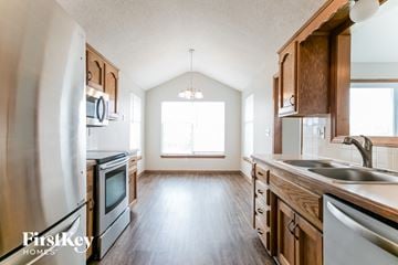 Greenwood house for rent - A kitchen with wooden cabinets and stainless steel appliances.