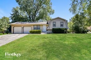Lee's Summit house for rent - a white house with a garage and a green lawn