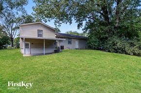 Lee's Summit house for rent - a house on a hill with a lawn and trees