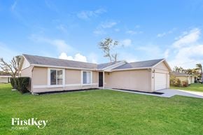 Cape Coral house for rent - A house with a lawn in front of it is for sale by FirstKey Homes.
