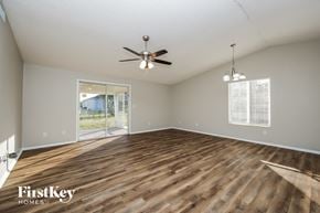 Cape Coral house for rent - A spacious room with wooden flooring and a ceiling fan.