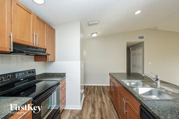 Cape Coral house for rent - A kitchen with wooden cabinets and a black stove top oven.
