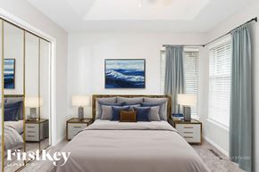 Greenwood house for rent - A bedroom with a large bed, two nightstands, and a painting on the wall.