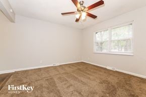 Blue Springs house for rent - an empty living room with a ceiling fan and a window