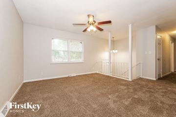 Blue Springs house for rent - a living room with carpet and a ceiling fan