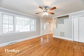 Summerville house for rent - an empty living room with a ceiling fan and a large window