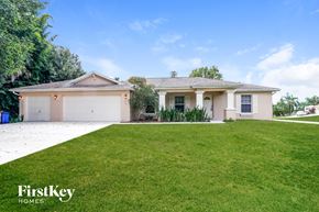 Fort Myers house for rent - A house with a white garage door and a brown roof is for sale.